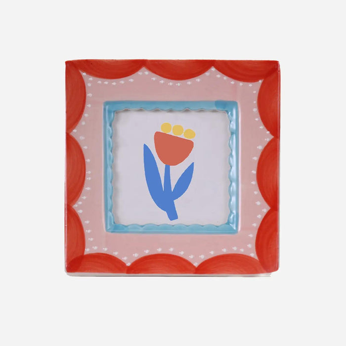 “Square hand-painted ceramic photo frame featuring red scalloped patterns on a white base.”

“Close-up of a red scallop ceramic frame displaying a small photo on a neutral background.”

“Hand-painted red and white scallop photo frame styled on a desk beside flowers and candles.”