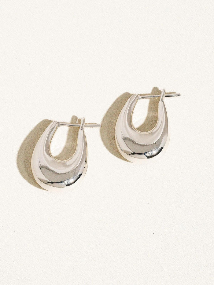 “Silver Droplet Hoop Earrings” – Elegant earrings on soft grey velvet with natural light

“18K Silver Hoops Minimal Style” – Close-up of earring worn with a neutral outfit